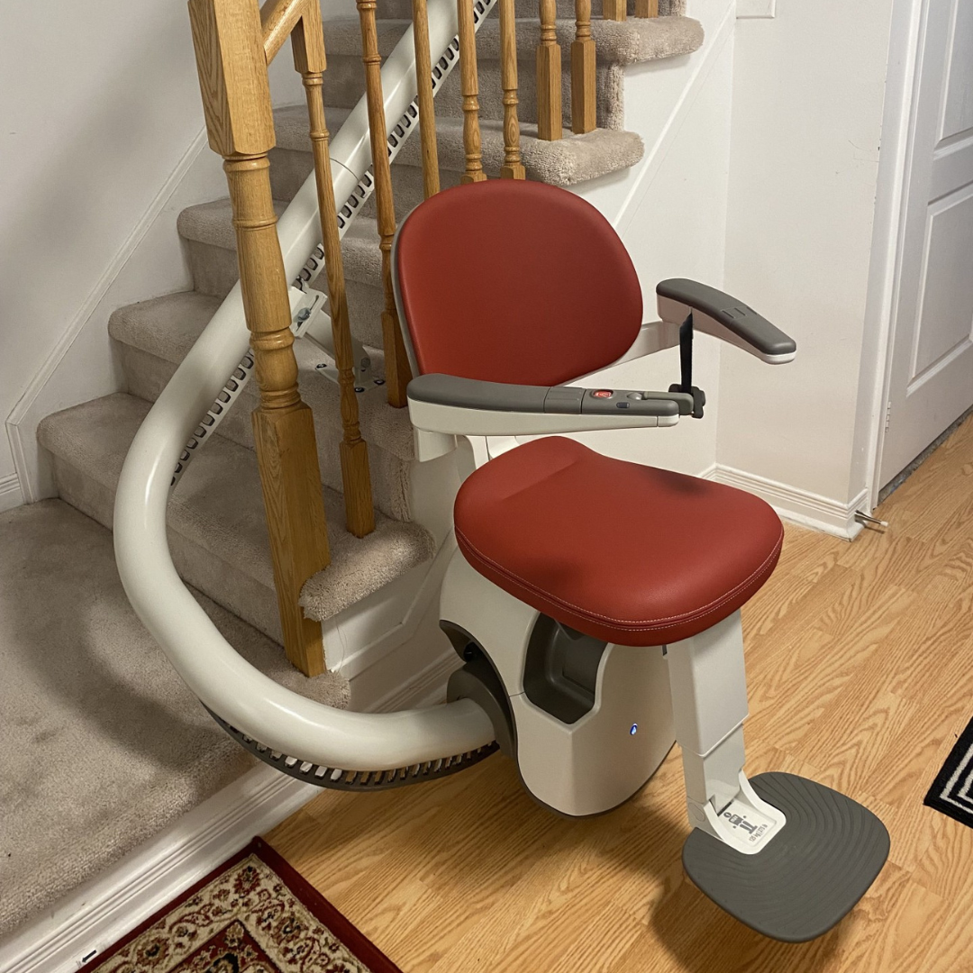 Red curved stairlift with Motion logo.